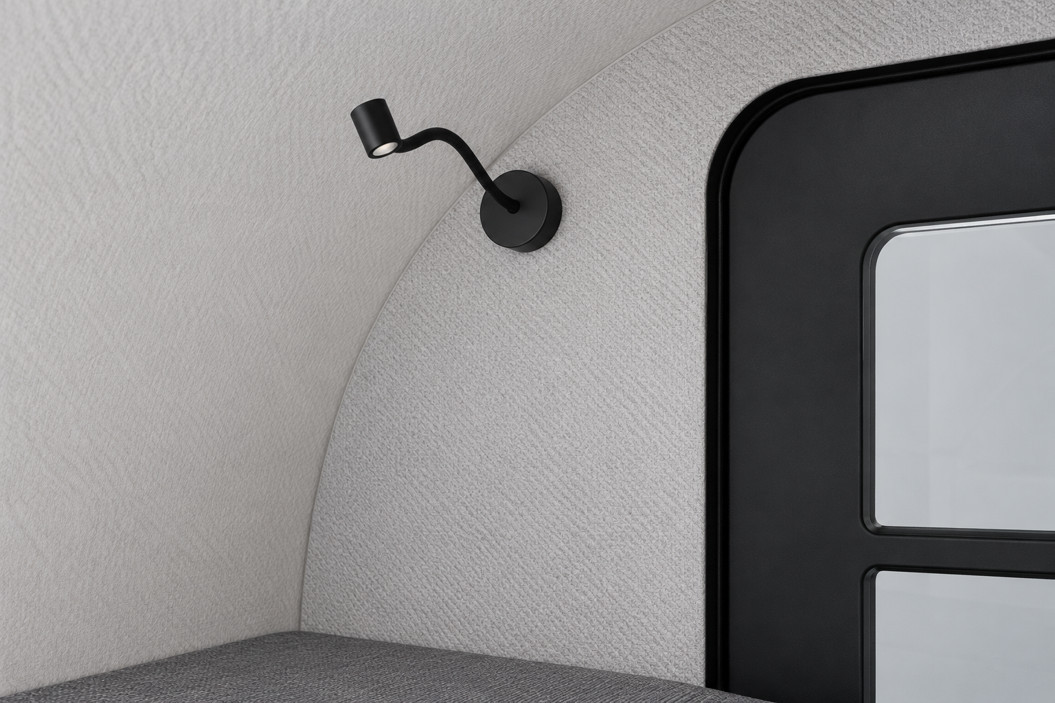 Black reading lamp beside the door in the Comma CC cabin